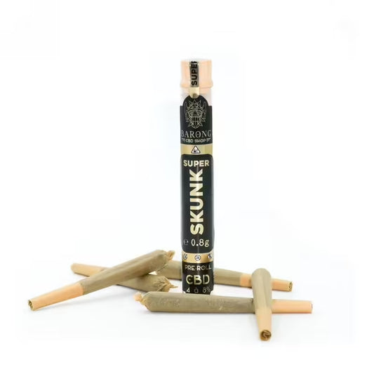 Joints pré-roulés au CBD soigneusement roulés, disposés sur une surface blanche propre, avec un joint légèrement ouvert révélant des fleurs de CBD finement moulues, entourés de feuilles de chanvre fraîches. Joints CBD premium sans tabac et sans nicotine.